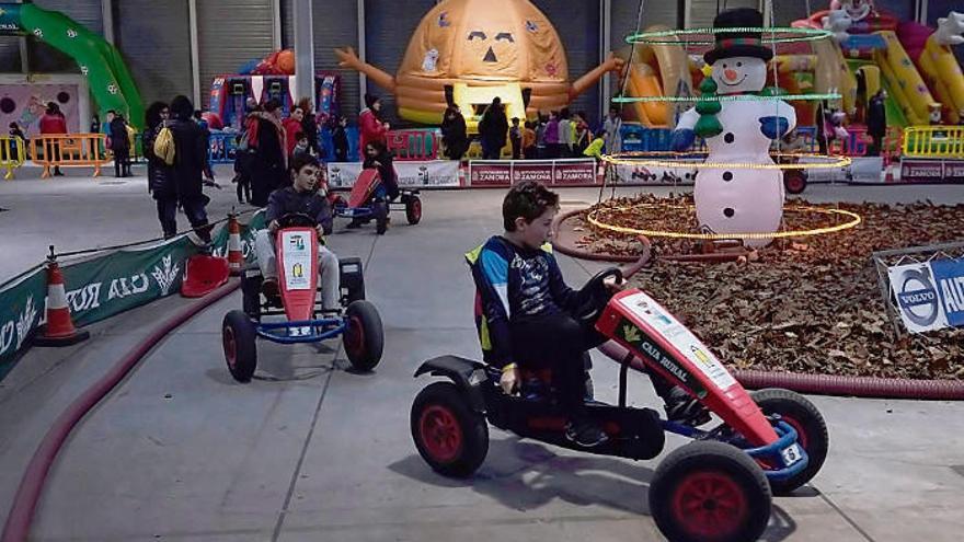 Niños montados en los coches de una actividad de la feria Muévete en Ifeza.