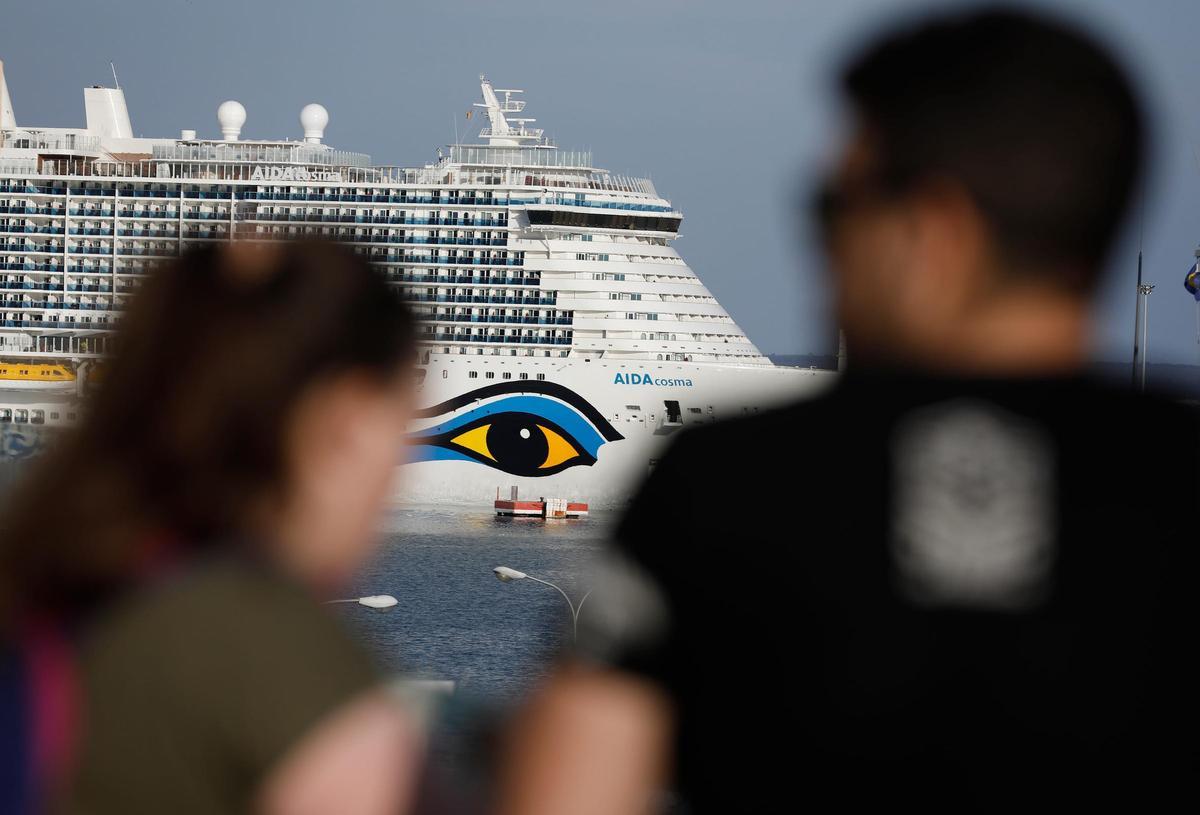 Menschen schauen nach dem Kreuzfahrtschiff Aidacosma, das im Hafen von Palma auf Mallorca angelegt hat.