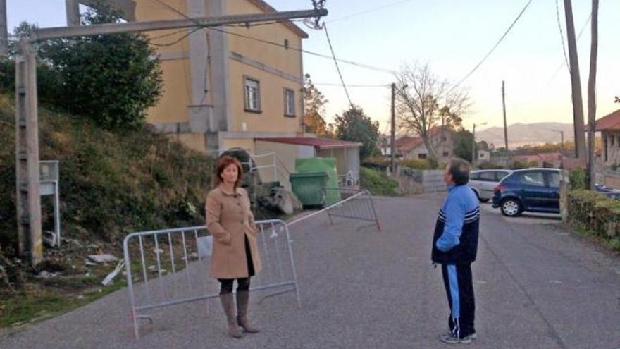 El poste sujeto por un alambre y el cable a cuatro metros del suelo, a dos de las cabezas de los vecinos.