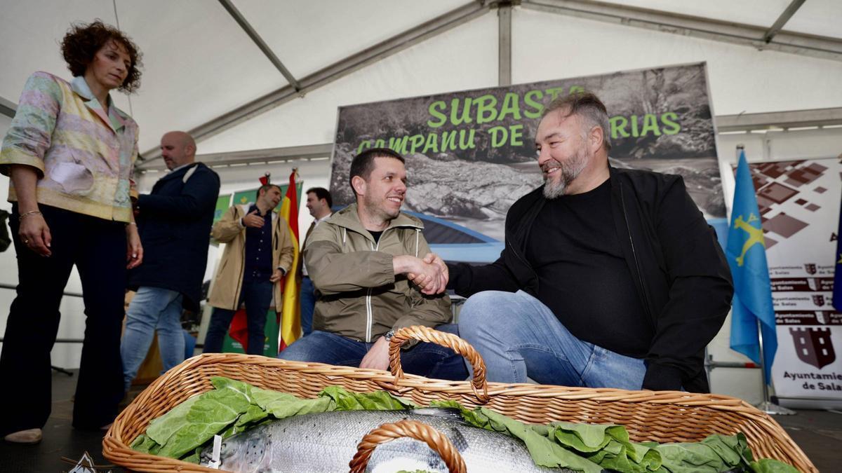 Javier Bueno, pescador del campanu del Narcea del año pasado, sella el acuerdo de venta con Pedro Caramés, en Cornellana.