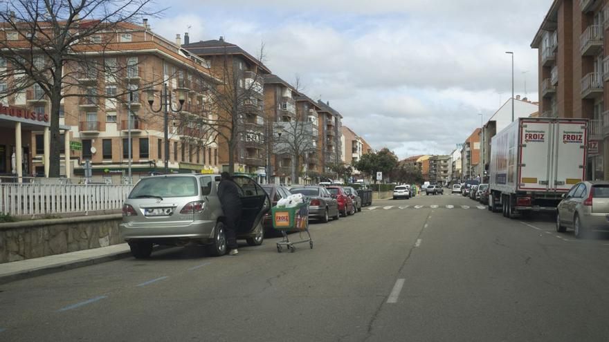 Una mujer carga en su vehículo un carrito de compra de un supermercado durante la pandemia.