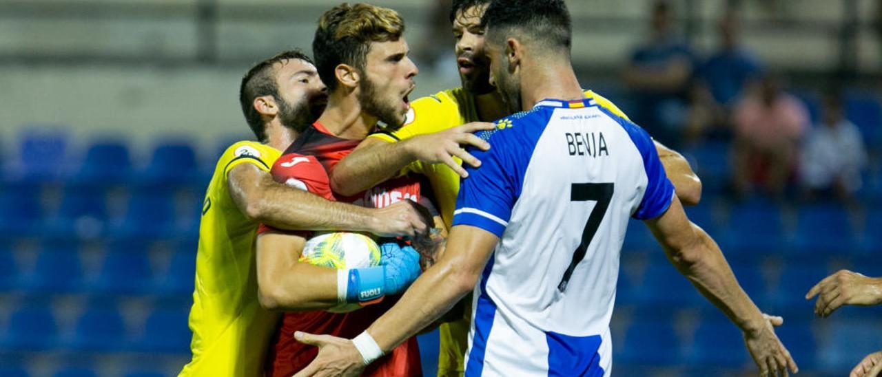 Dos jugadores del Villarreal B tratan de separar al portero Diego Licinio y al delantero blanquiazul Benja.