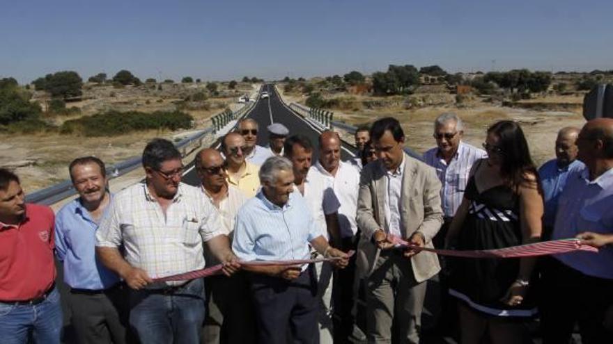 El presidente de la Diputación corta la cinta inaugural de la carretera, junto al resto de autoridades locales.