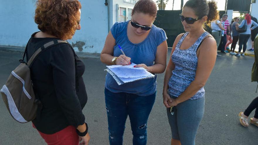 Una madre firma un escrito de las familias del colegio, ayer.