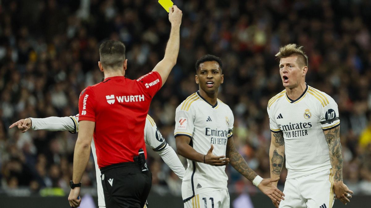 El árbitro Díaz de Mera Escuderos muestra la tarjeta amarilla a Toni Kroos durante un Real Madrid-Sevilla.