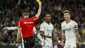 El árbitro Díaz de Mera Escuderos muestra la tarjeta amarilla a Toni Kroos durante un Real Madrid-Sevilla.