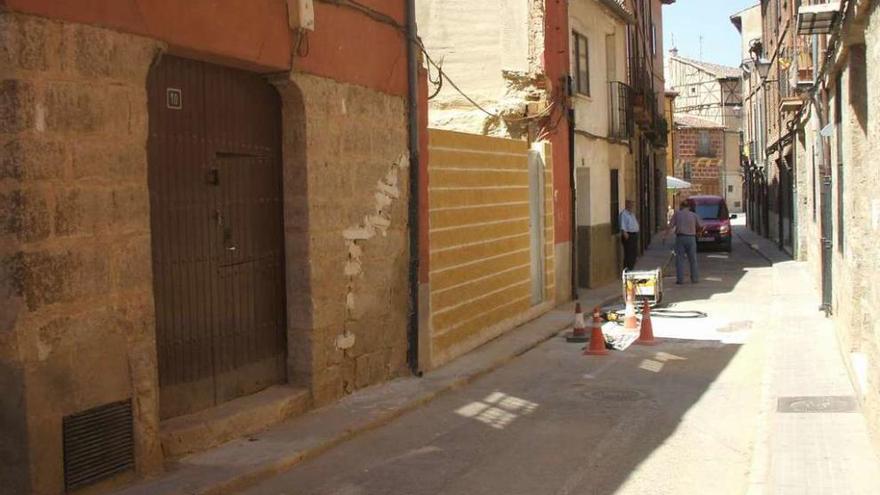 Dos vecinos pasean por la calle San Lorenzo, cortada al tráfico desde hace varios meses.