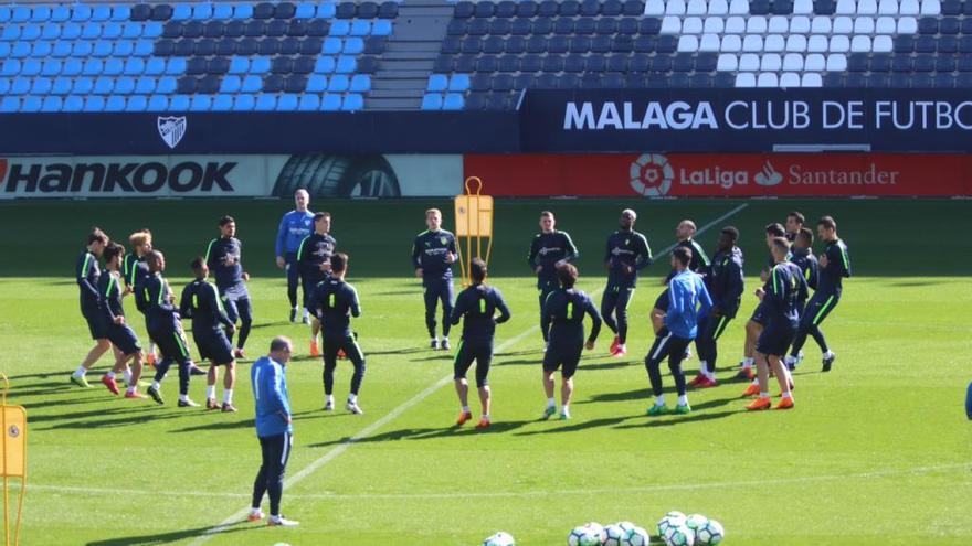 Los jugadores del Málaga CF, sobre el césped del escenario del partido de hoy.