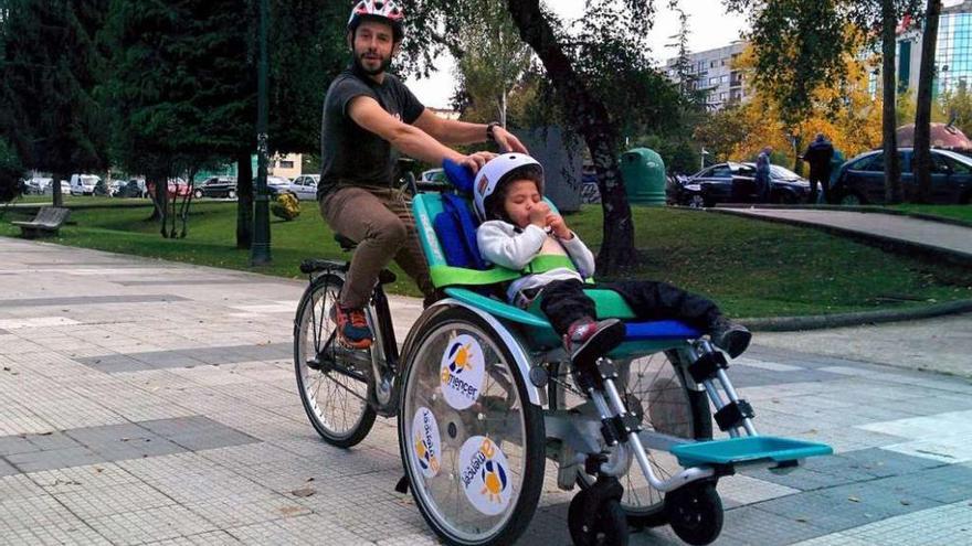 Manuel Torres pasea por Campolongo a Sofi, una niña de cuatro años con ceguera y sordera. // FdV