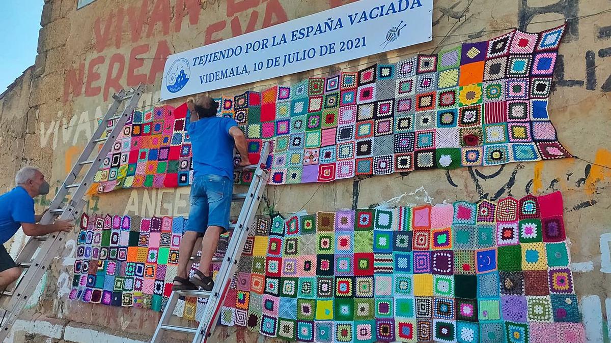 Colocación de los tapetes de los ganchillos en la pared trasera de la iglesia de Videmala. | Ch. S.