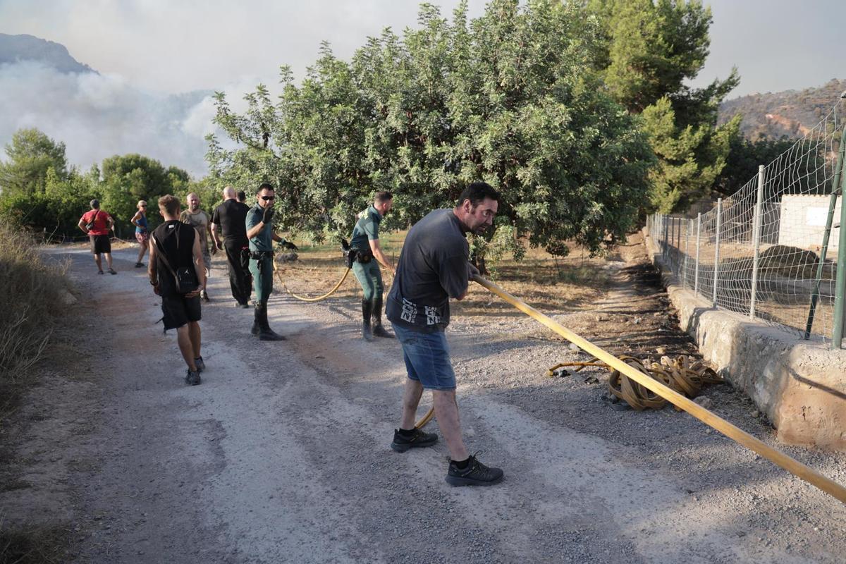 Vecinos y vecinas de la Vall d'Uixó tratan de ayudar a frenar el fuego del incendio.