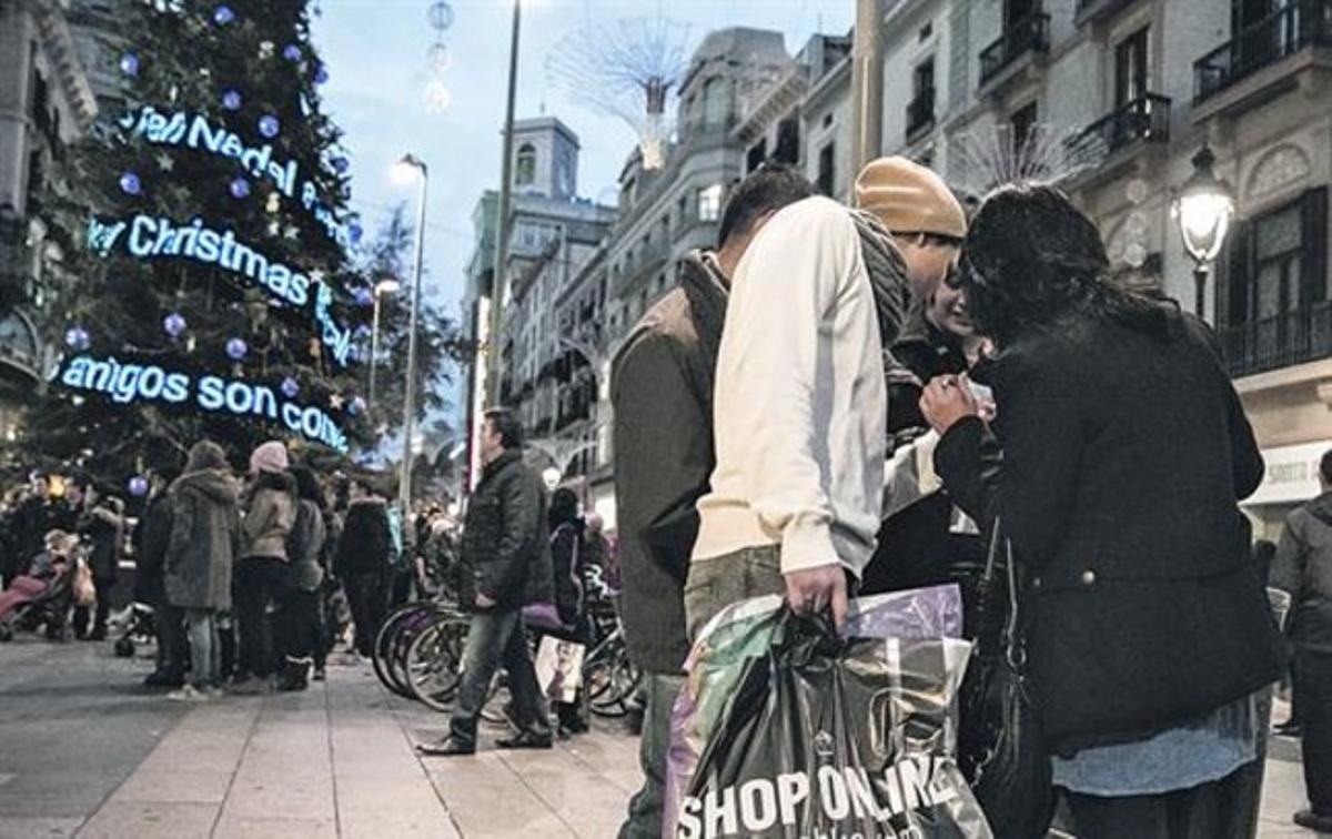 Transeünts amb bosses de compres ahir, al Portal de l’Àngel de Barcelona.