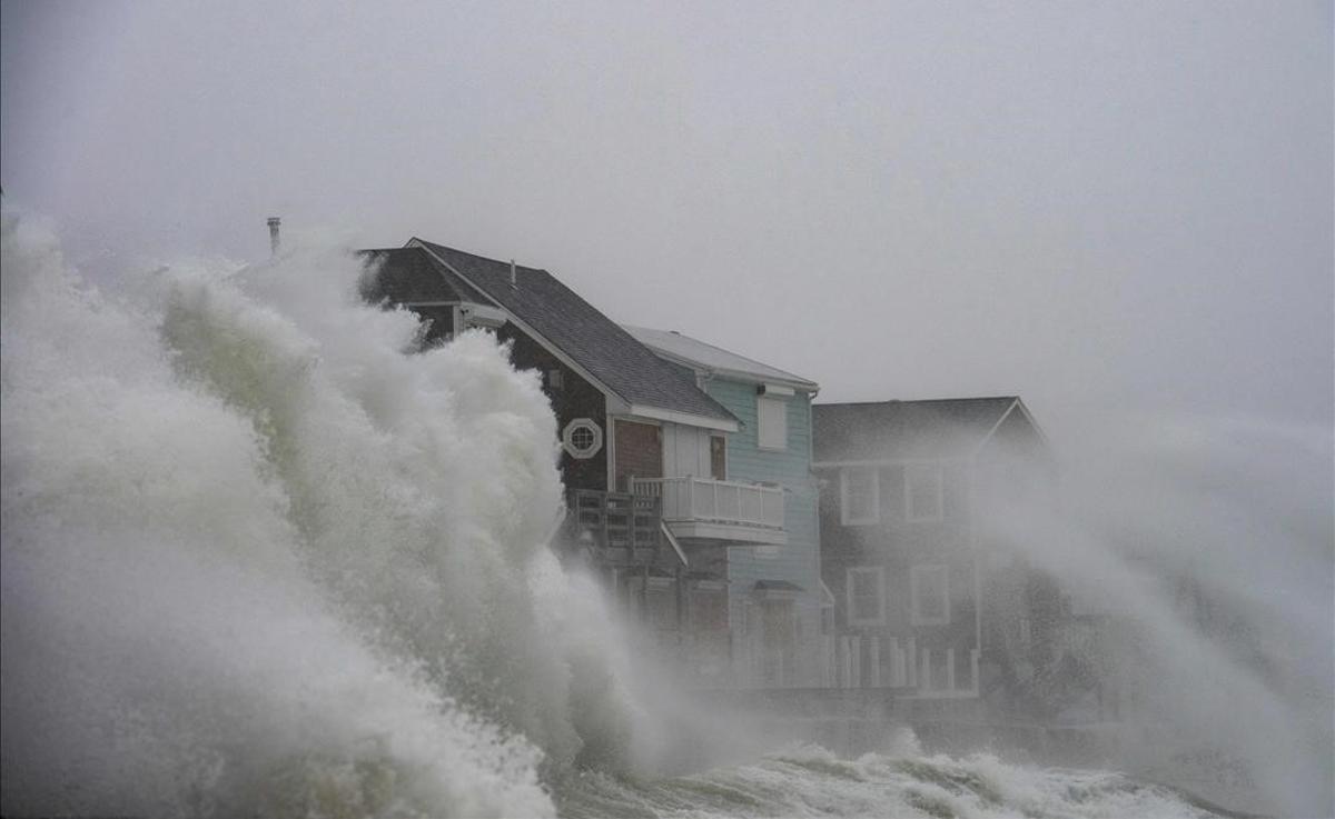 Las olas rompen contra unas casas situadas en primera línea de la costa, durante una tormenta invernal en la localidad de Scituate, Massachusetts, en diciembre del 2020.