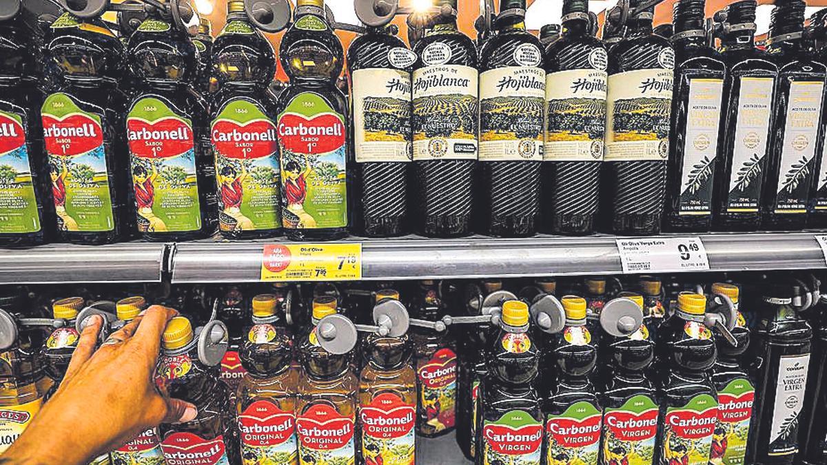 Un lineal con botellas de aceite de oliva en un supermercado.