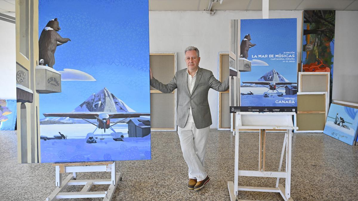 Charris posa en su taller junto con la obra original y el cartel de La Mar.
