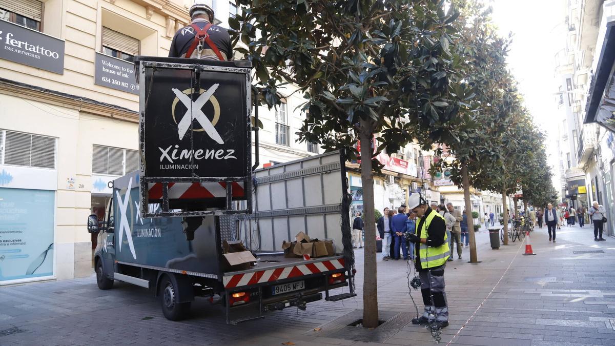Operararios de Ximenez en la calle Cruz Conde instalando el espectáculo de luz y sonido de Navidad