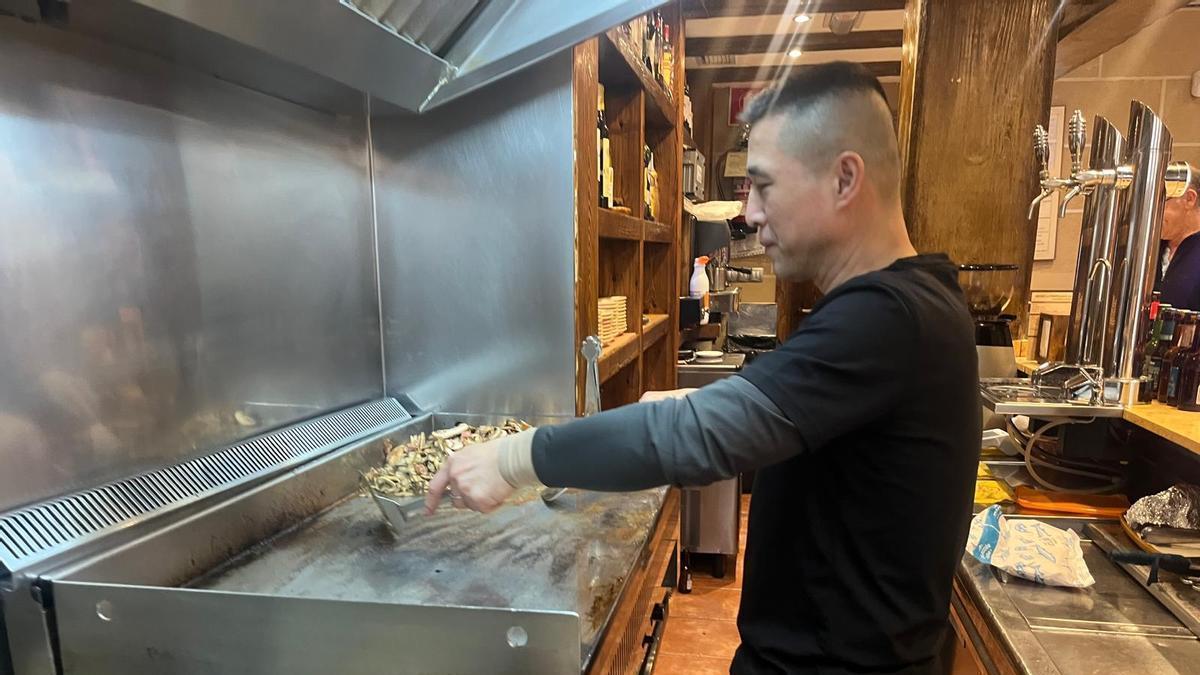 Felipe Wang prepara los champis en la plancha de La Bodeguilla.
