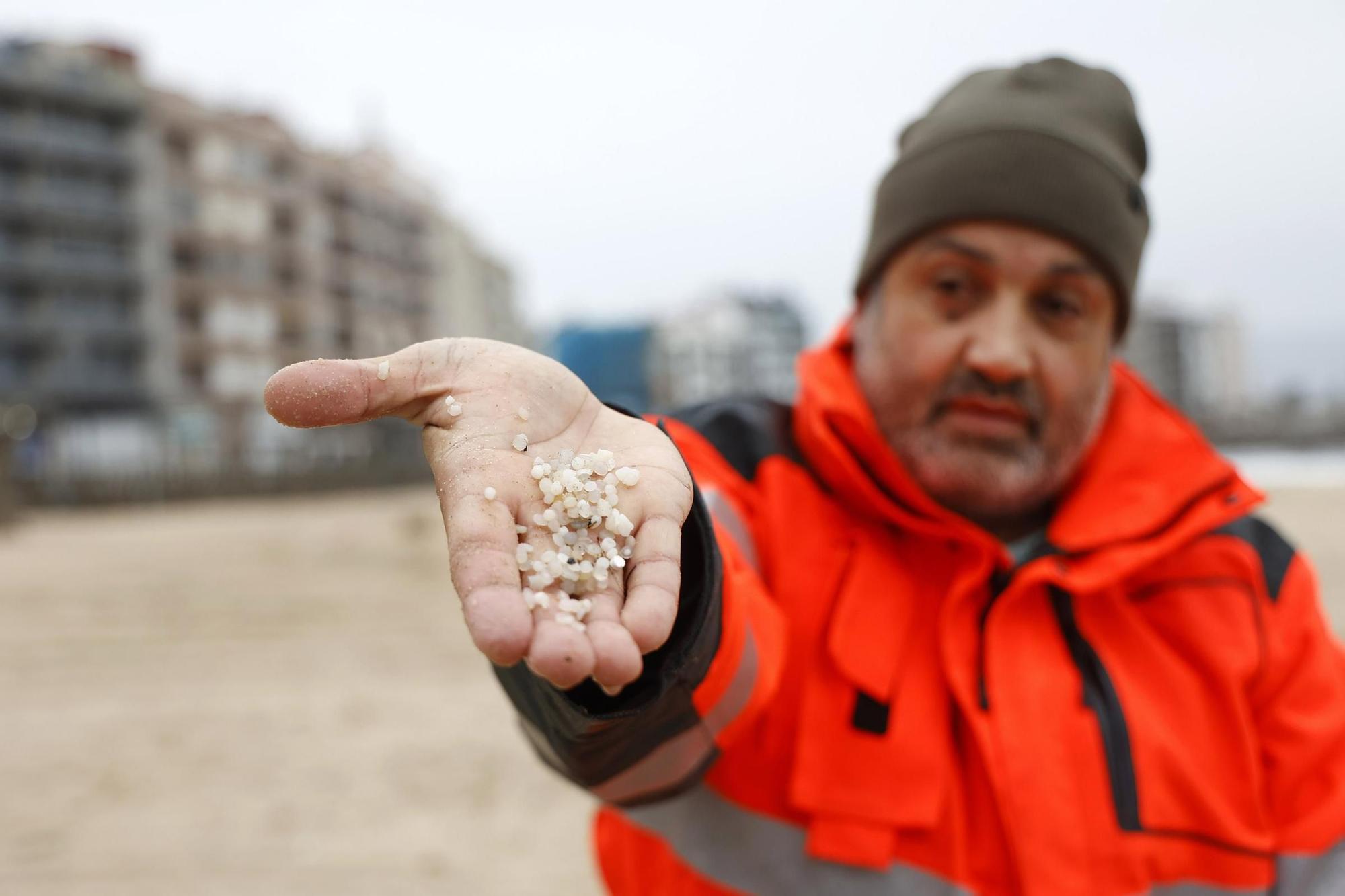 Un trabajador del concello de Sanxenxo muestra los pellets recogidos en la playa de Silgar