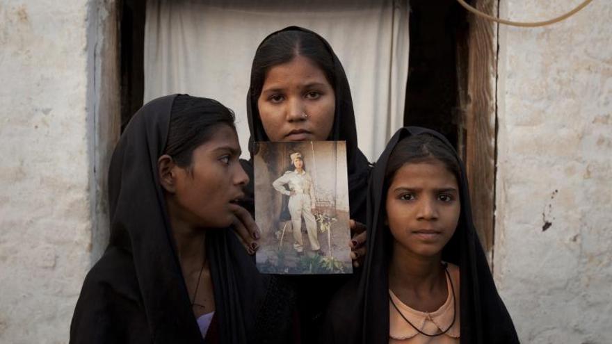 Las hijas de Asia Bibi posan con una foto de su madre.