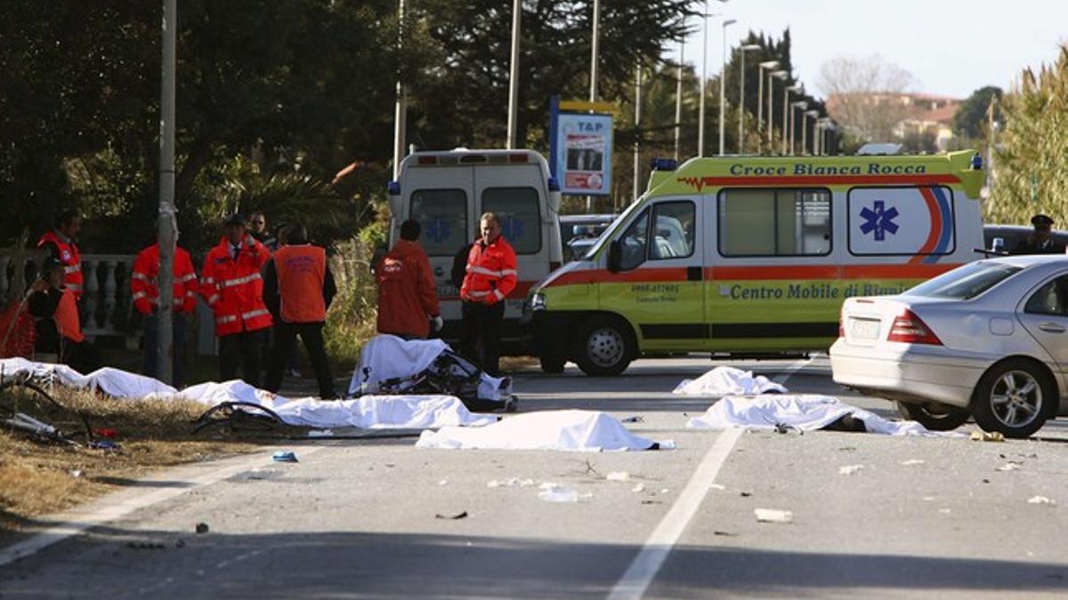 Cuerpos de los ciclistas en el lugar del accidente, una carretera recta.