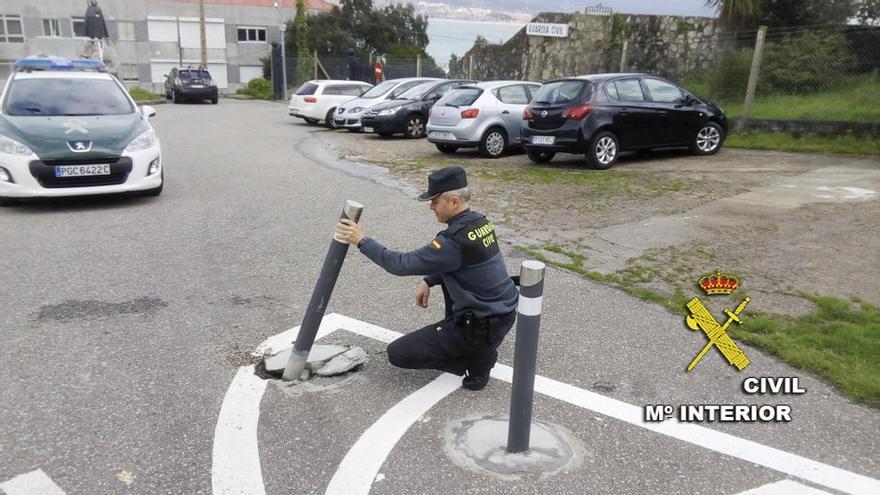 Un agente muestra el bolardo derribado en el aparcamiento del cuartel baionés. // Guardia Civil