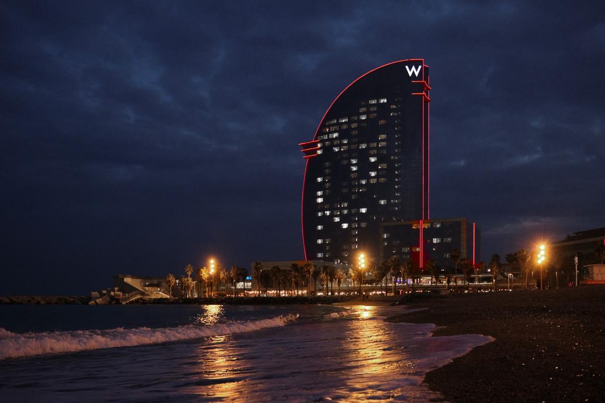 L’Hotel W de Barcelona es tenyeix de vermell quan l’equip Alinghi de la Copa Amèrica de Vela surt a navegar