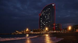 El equipo de Alinghi Red Bull Racing ilumina el Hotel W de Barcelona el día antes de salir a navegar.