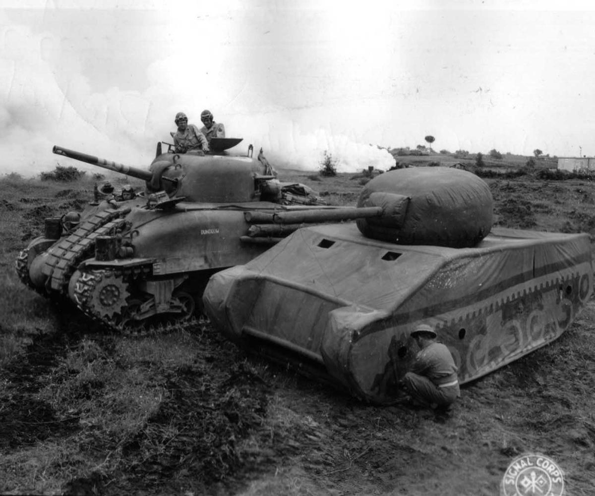 Un soldado pinta un tanque inflable durante la Segunda Guerra Mundial