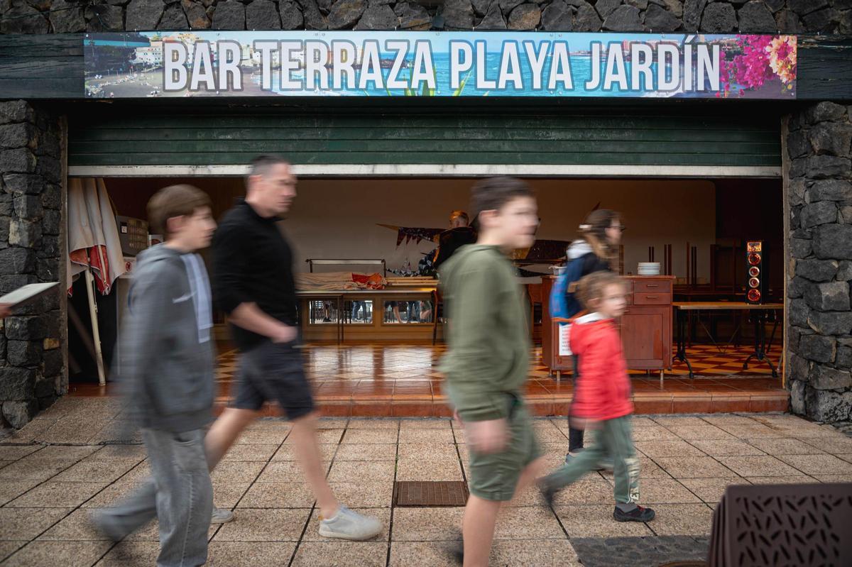Turistas paseando por delante de uno de los bares de Playa Jardín