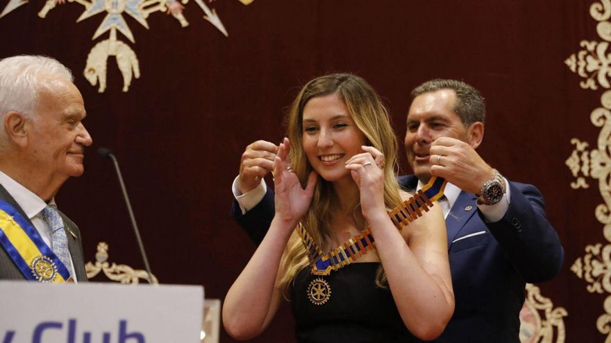 José Piloñeta pone el collar del Rotary Club a Elisa Costales ante la atenta mirada de Ramiro Fernández. | FERNANDO RODRÍGUEZ