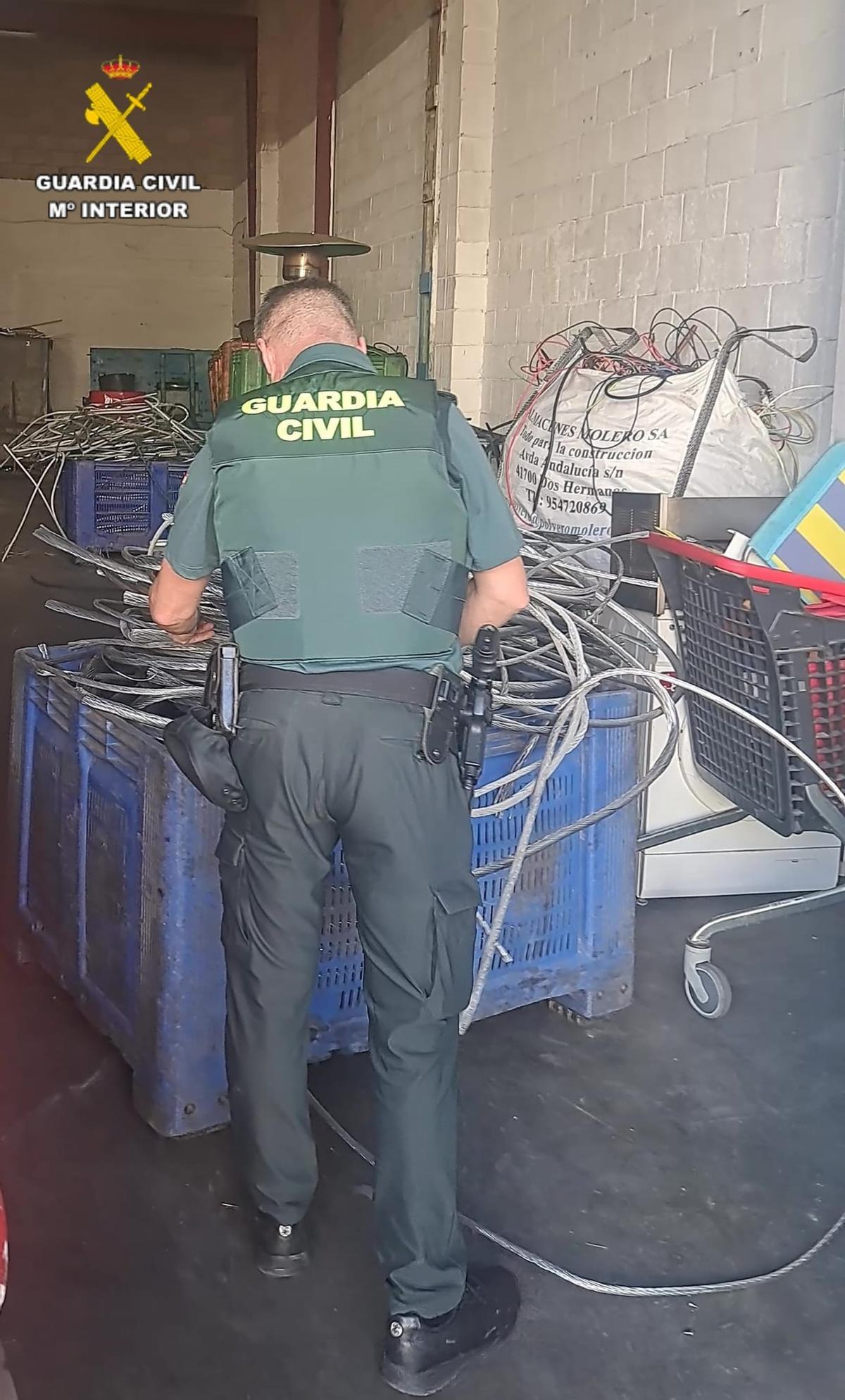 Un agente de la Guardia Civil con los efectos robados.