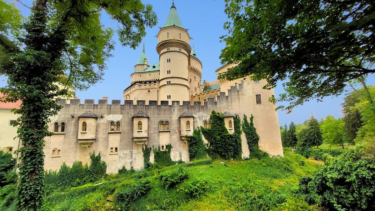 Castillo medieval de estilo cuento de hadas, con torres redondas y agujas verdes