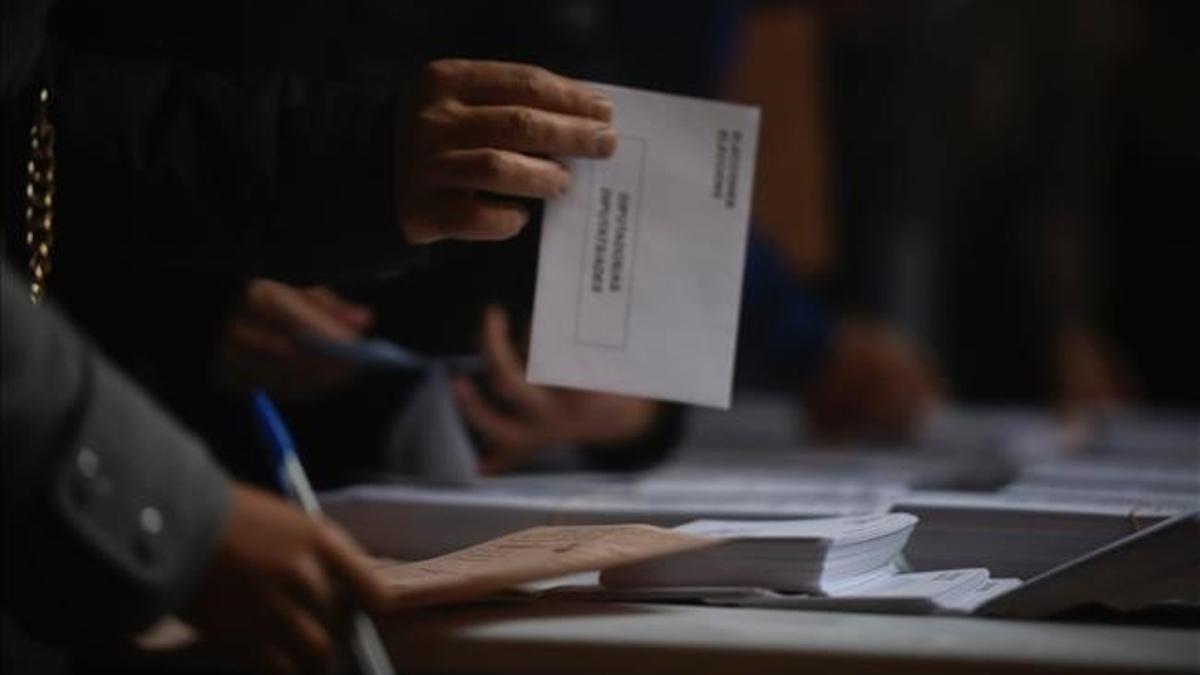 Un elector con su sobre en la mano en un colegio electoral en el 2019.