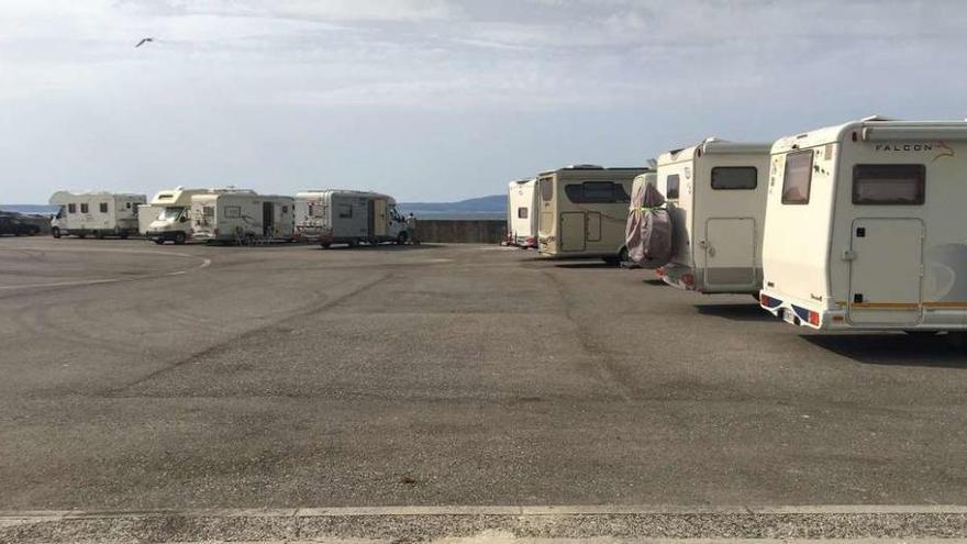 Autocaravanas estacionadas en la explanada portuaria de O Corgo, detrás de la lonja y las casetas de usos pesqueros. // Muñiz