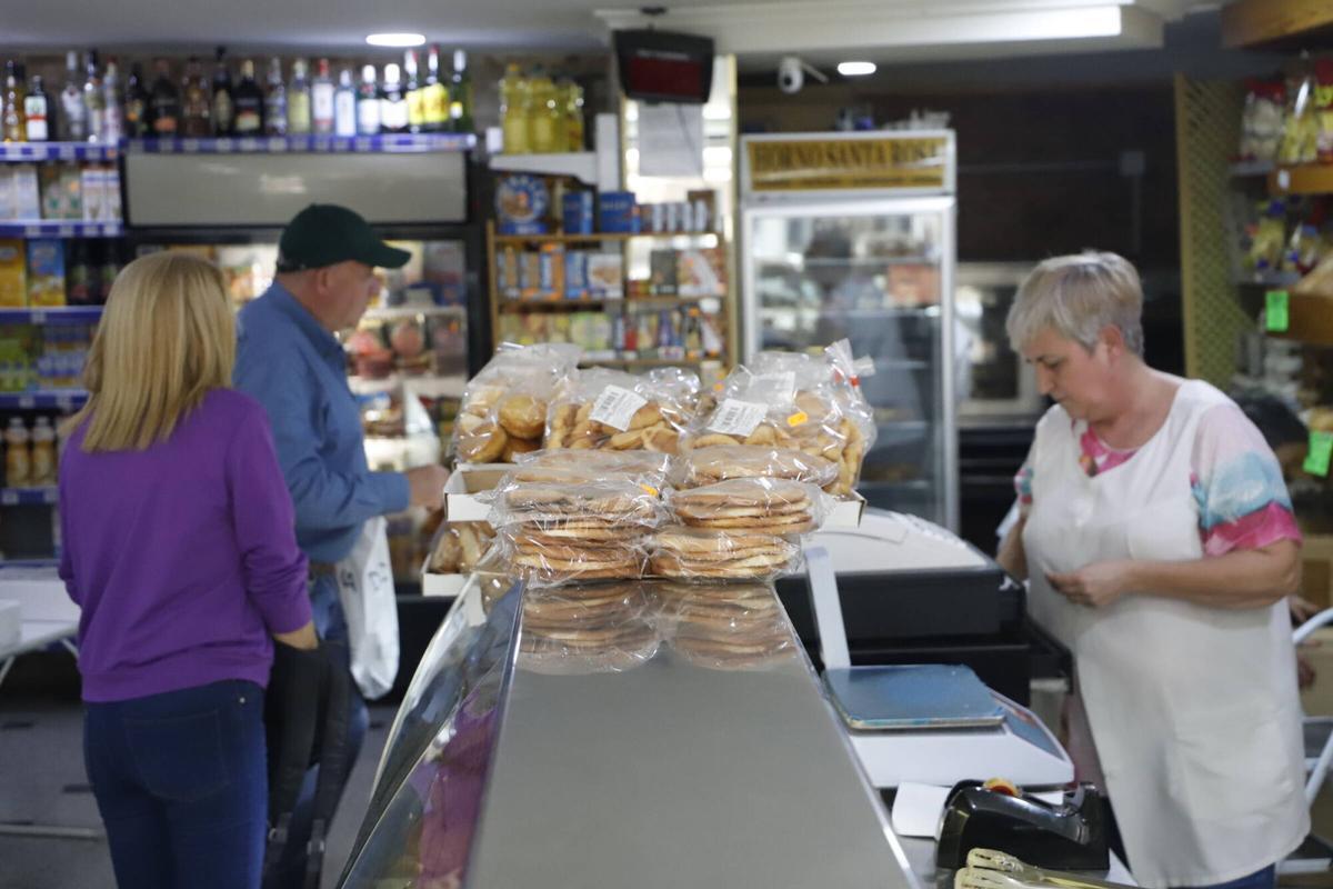 Unas tortas de aceite mientras María Ángeles Cubero atiende a unos clientes de fondo.