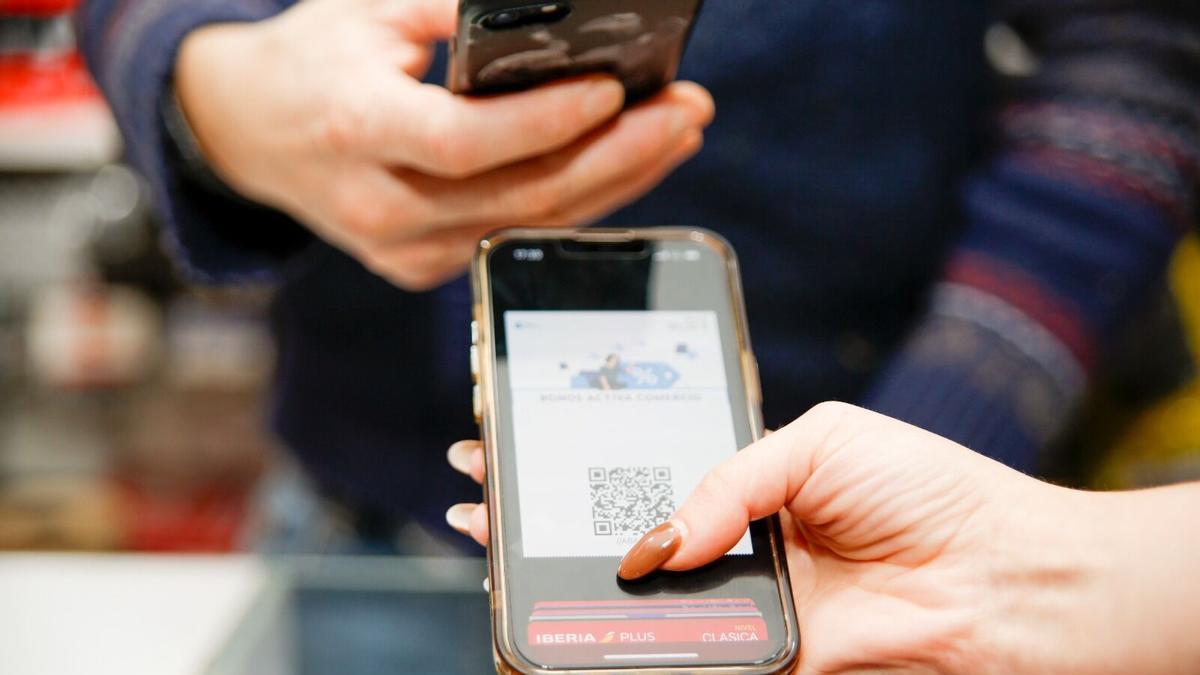 Un cliente usa el Bono Activa Comercio de la Xunta para comprar.