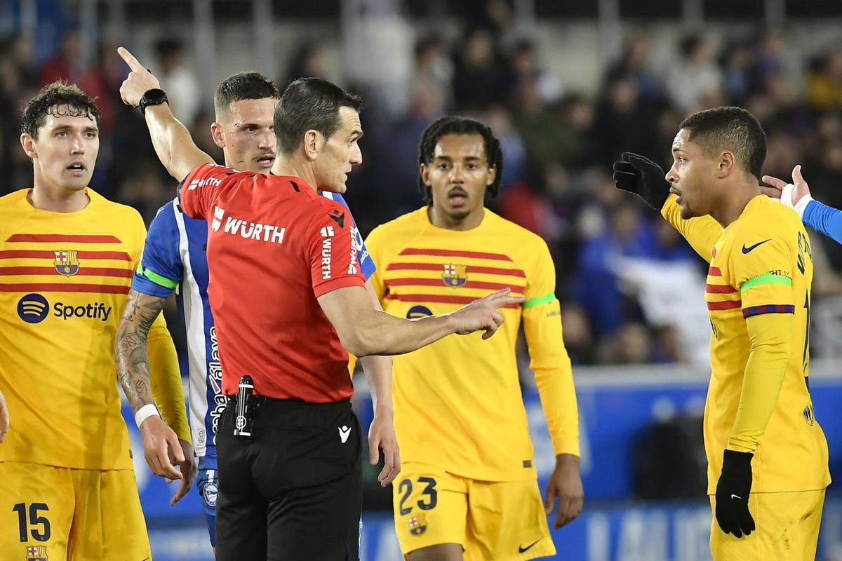 Players argue with referee Juan Martinez Munuera during the La Liga soccer match between Deportivo Alaves and FC Barcelona at the Medizorrosa stadium in Vitoria, Spain, Saturday, Feb. 3, 2024. (AP Photo/Alvaro Barrientos)