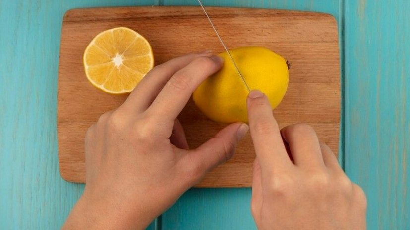 Una persona corta un limón por la mitad
