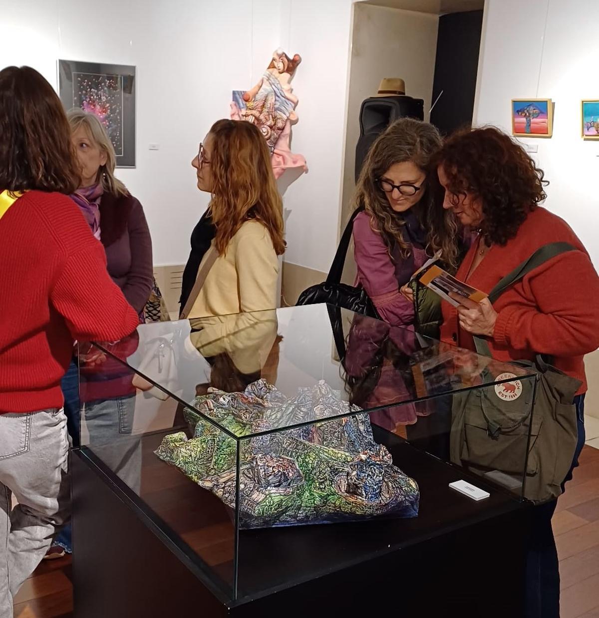 Asistentes a la inauguración observan uno de las obras