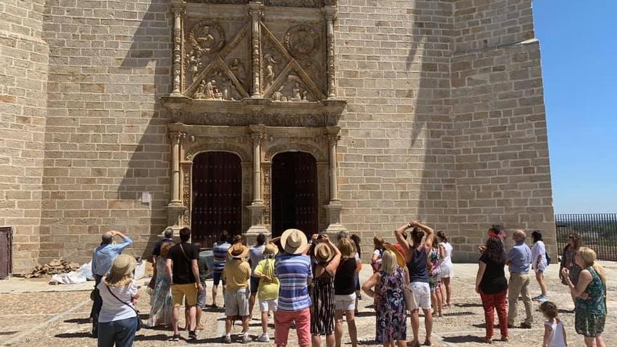Un grupo de turistas observa uno de los muros de la catedral de Coria, en un verano anterior.