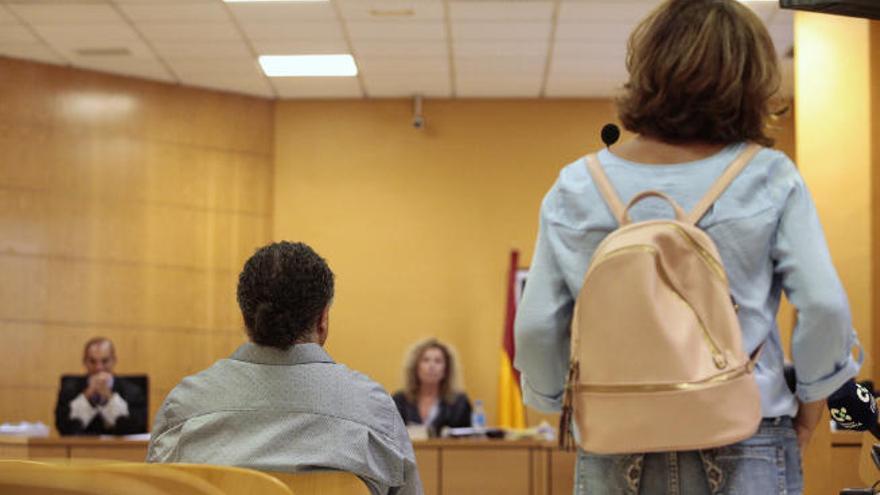 El acusado, sentado frente al tribunal, escucha la declaración de la madre del denunciante.