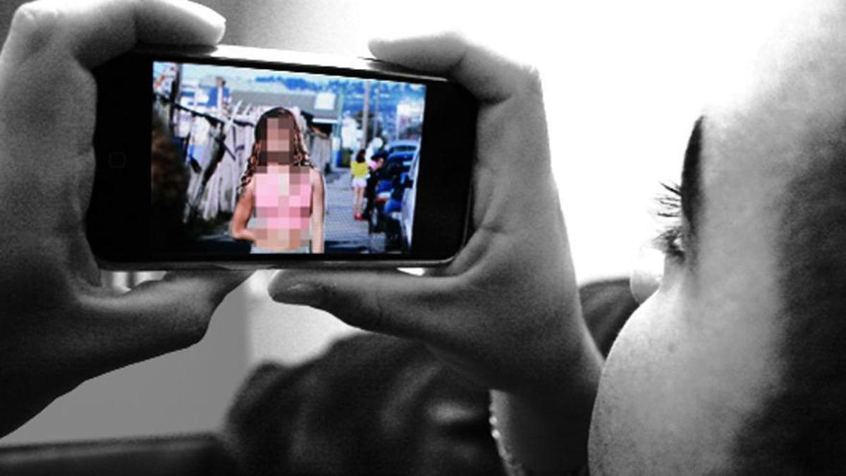 Imagen de archivo de un menor viendo una foto de un desnudo en su móvil.