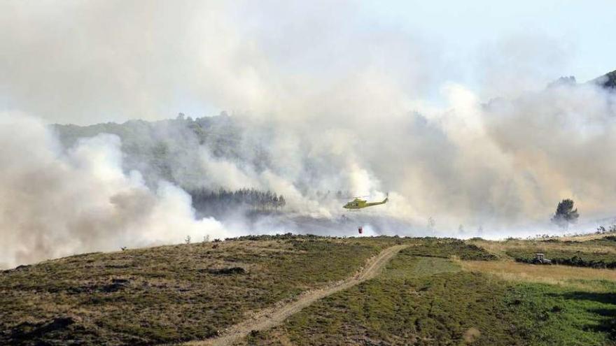 Un helicóptero transporta agua en las labores de extinción del incendio. // Bernabé/Javier Lalín