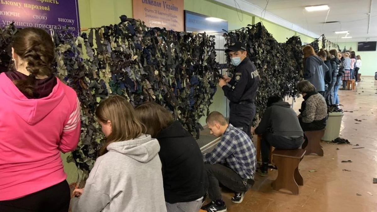 En el Instituto de Investigación y Educación Krivnyy Rih, civiles cortan trozos de tela y preparan redes de camuflaje para proteger a los blindados ucranianos.