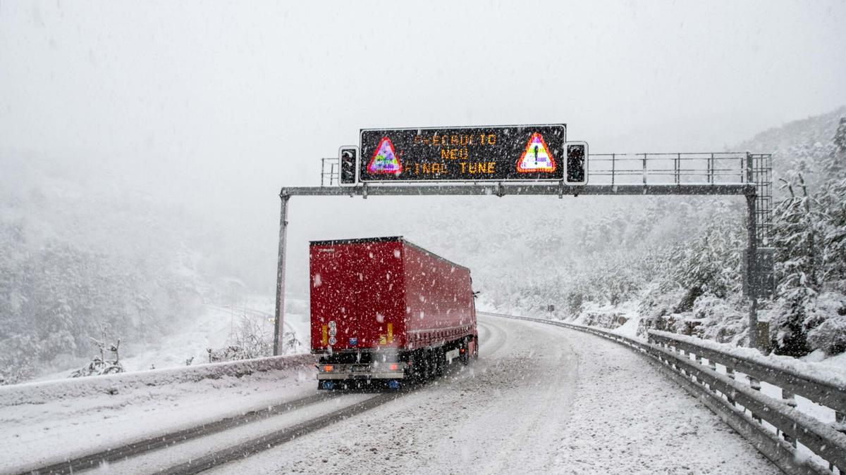 Un camión circulando por una carretera nevada, en una imagen de archivo