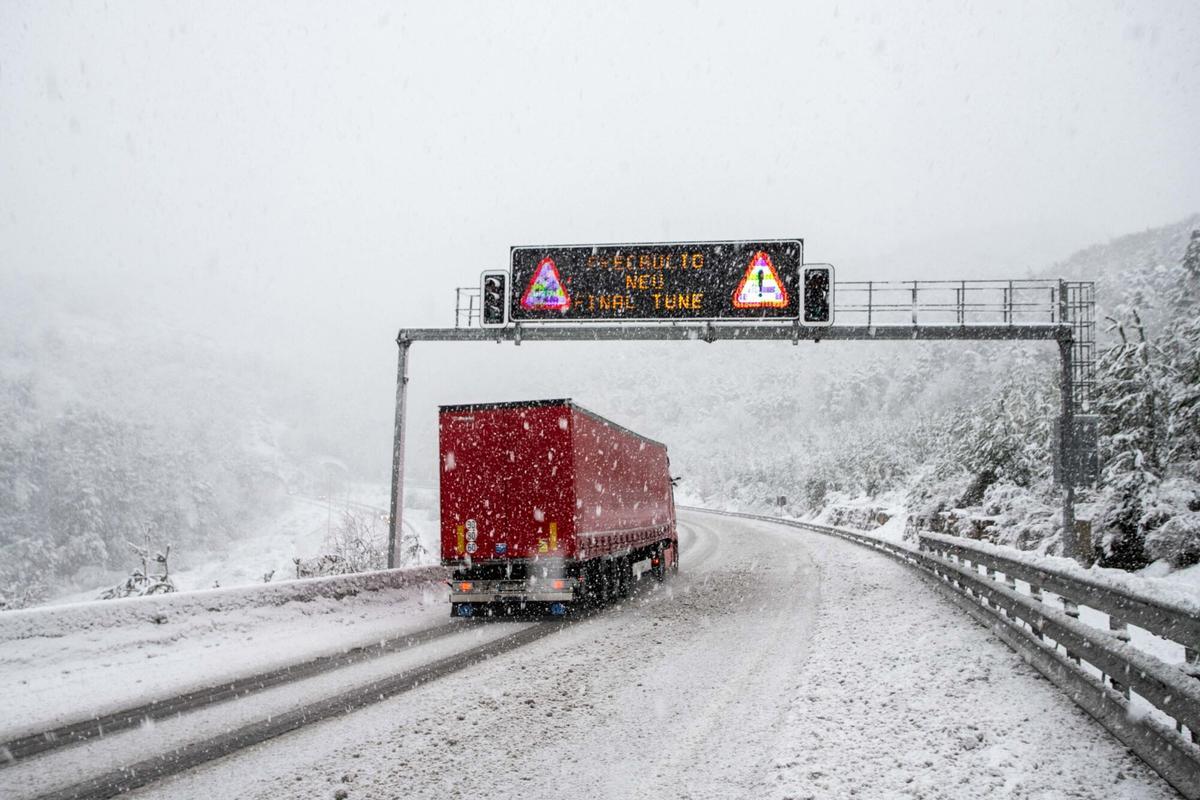 Un camión circulando por una carretera nevada, en una imagen de archivo