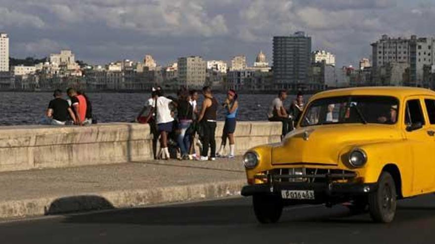 Un coche circula ante el malecón de La Habana.