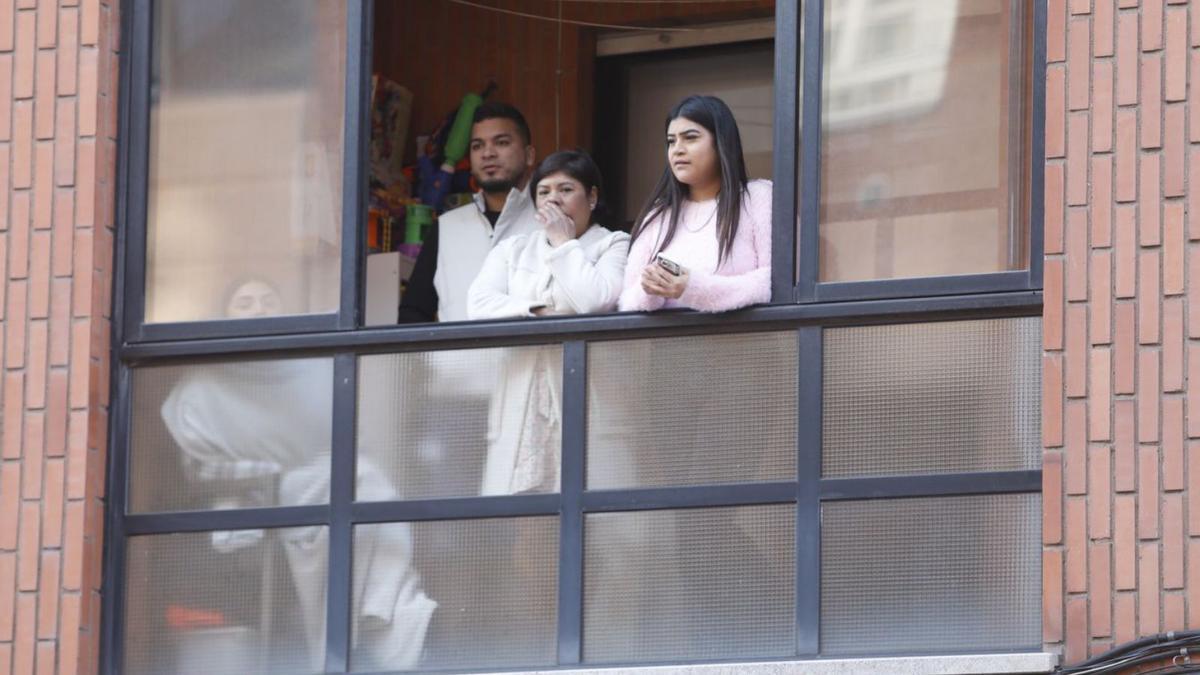 Una familia del bloque de enfrente, asomada al balcón.