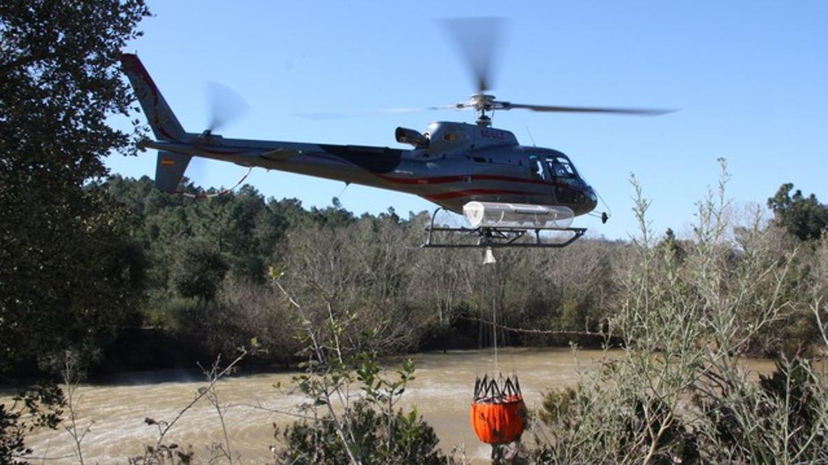 Uno de los helicópteros recoge agua durante las tareas de extinción