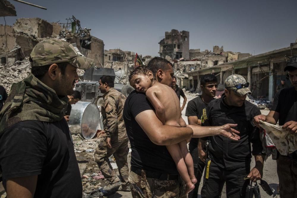 Un niño no identificado, que fue llevado fuera de la última área controlada por ISIS en la Ciudad Vieja por un hombre sospechoso de ser un militante, es cuidado por soldados de las Fuerzas Especiales iraquíes.